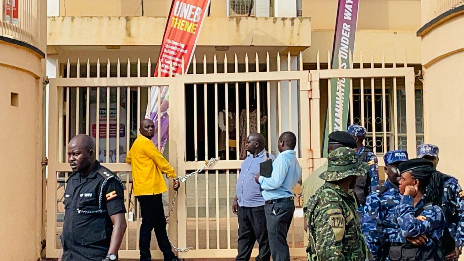 Atwiine Chains Himself to UNEB Gate After EC Disqualifies Him From MP Race